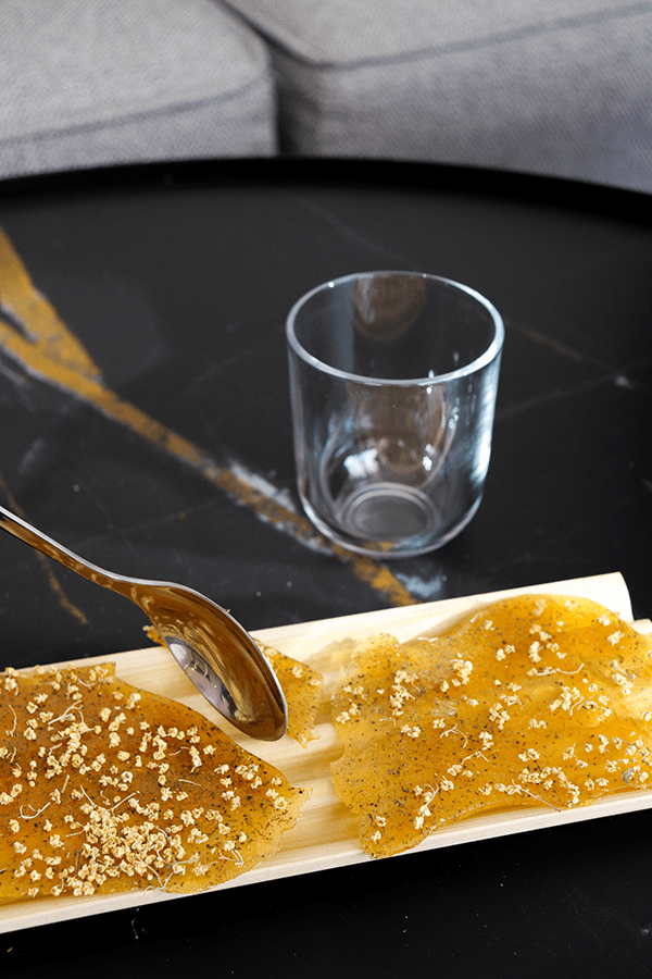 Un plato de comida con una cuchara y un vaso sobre una mesa. Mersi Studio