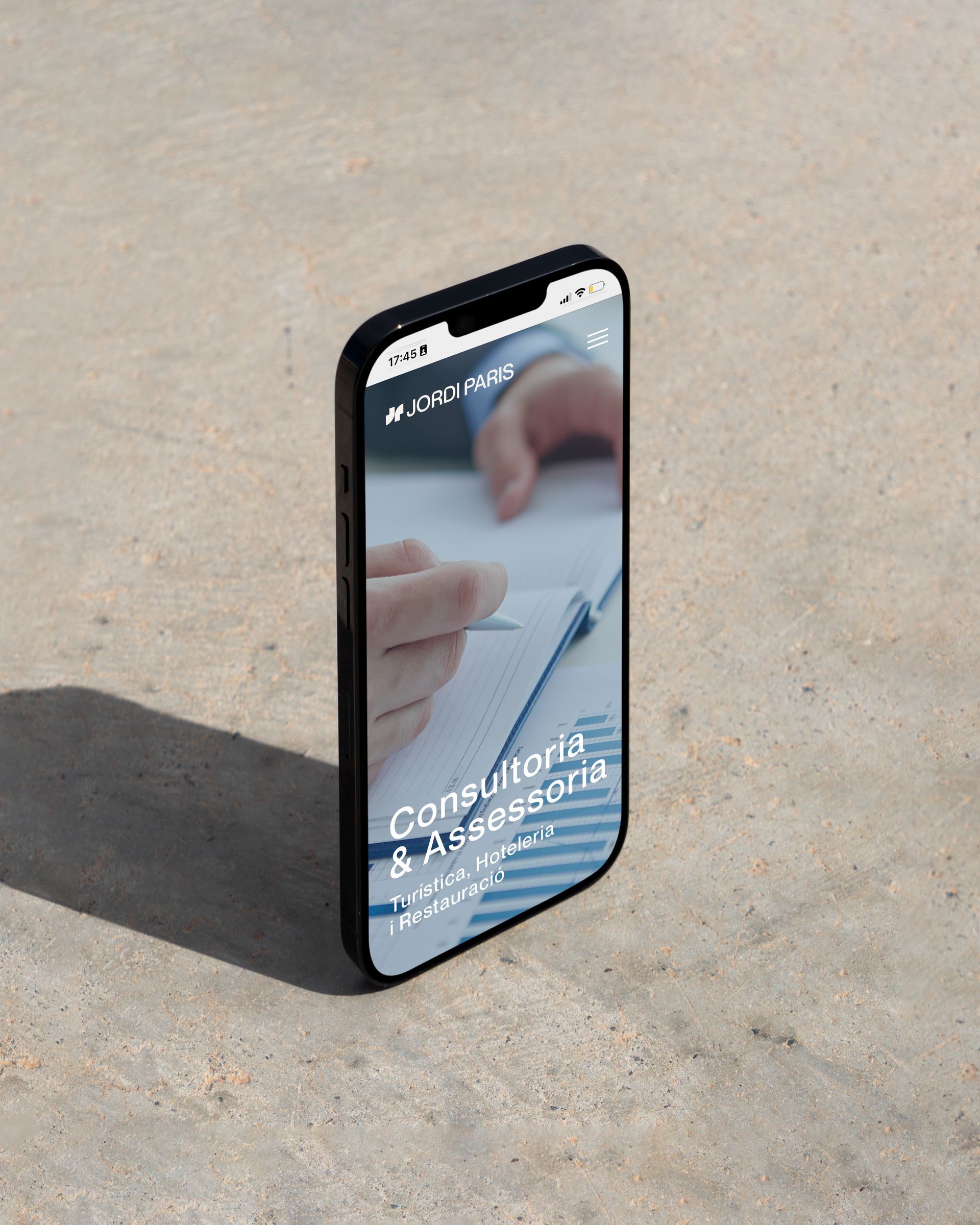 Un telèfon mòbil con la nueva web de JP Consultoria hotelera hecha por el estudio de diseño Mersi Studio. 

