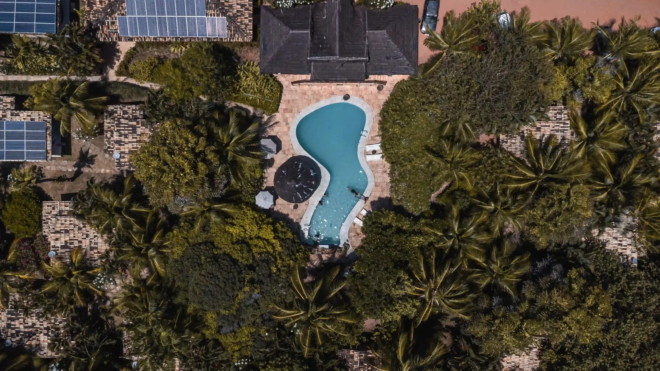 Uma vista aérea de uma grande piscina cercada por palmeiras.-Pousada-Imperio-do-Sol