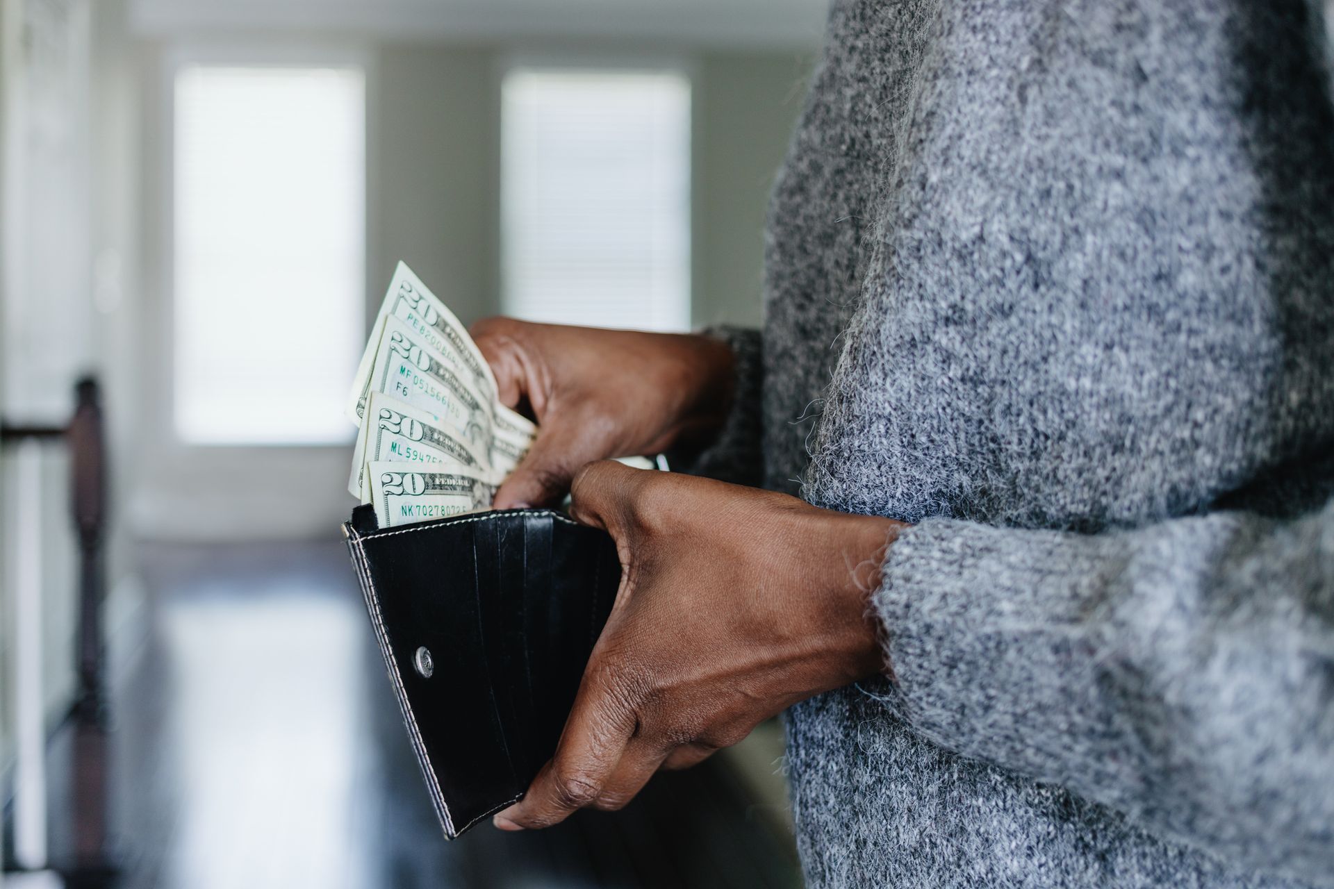 A woman is taking money out of her wallet.