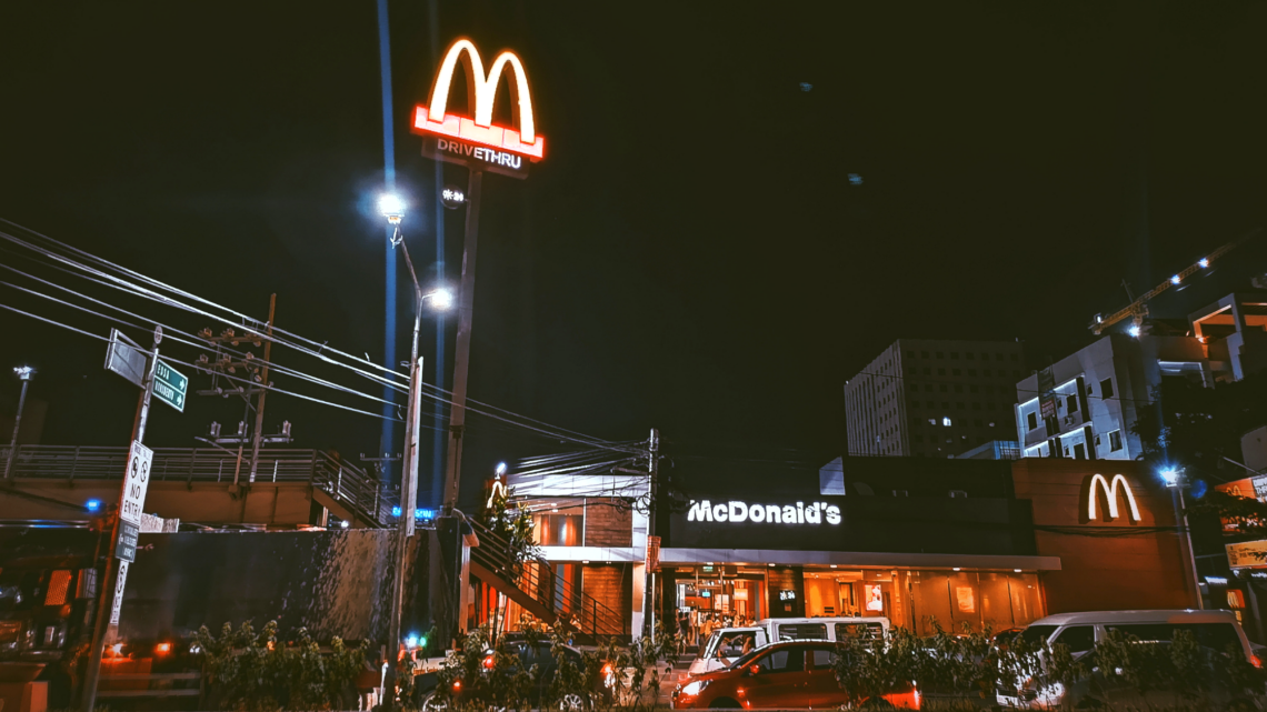 A McDonald's franchise restaurant is lit up at night.