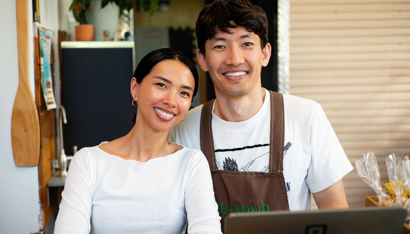 Cafe owners standing behind the counter, illustrating the process of becoming a franchise owner