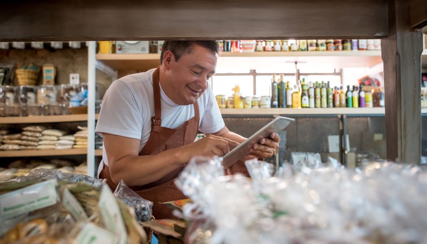 A man is looking at a tablet in a store.