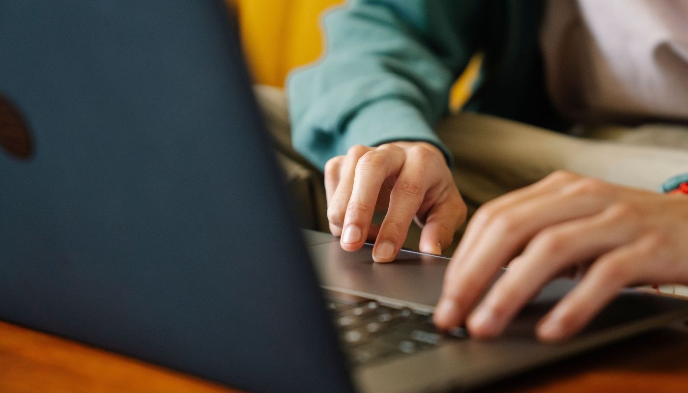 Person typing on laptop and doing research on reliable franchise advisory services