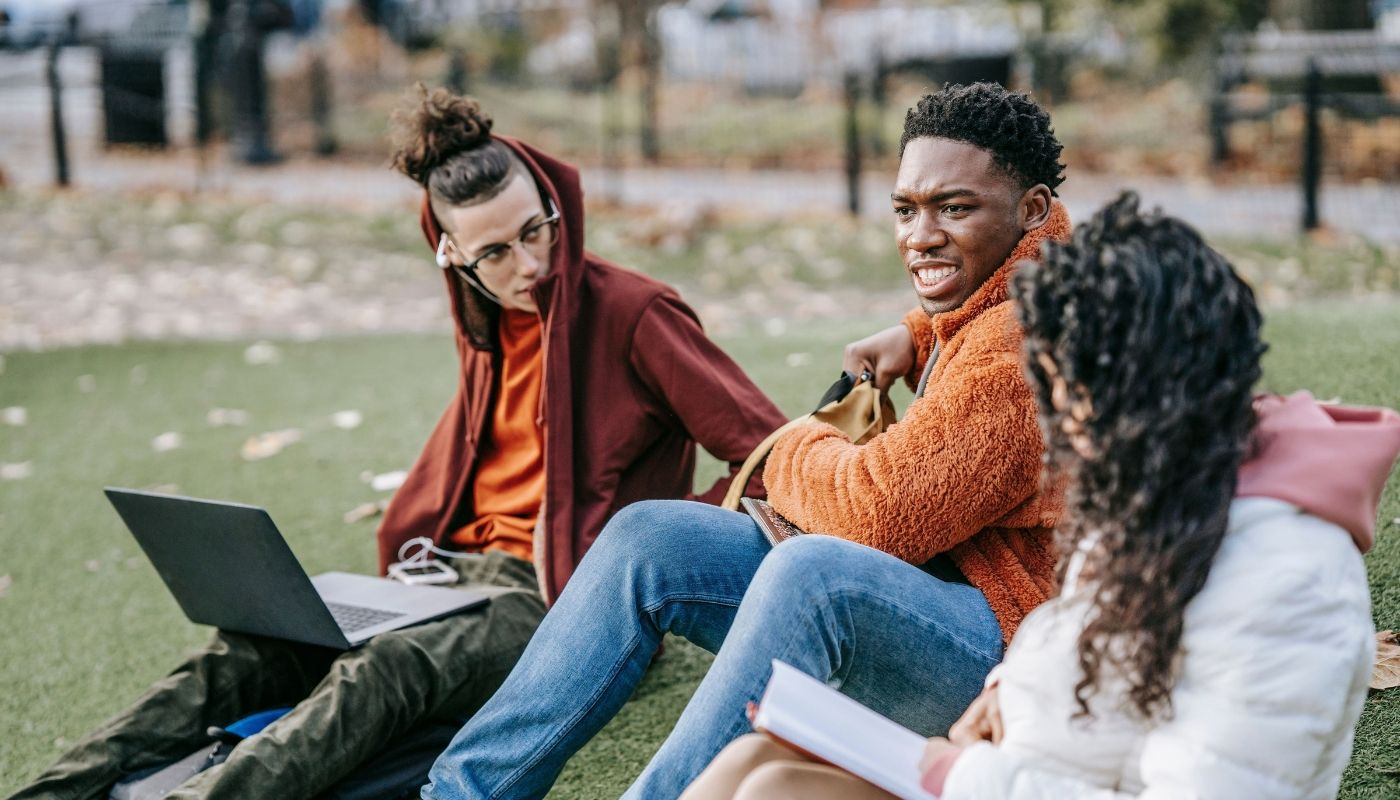 Group of students in a park, discussing franchise opportunities for Gen Z