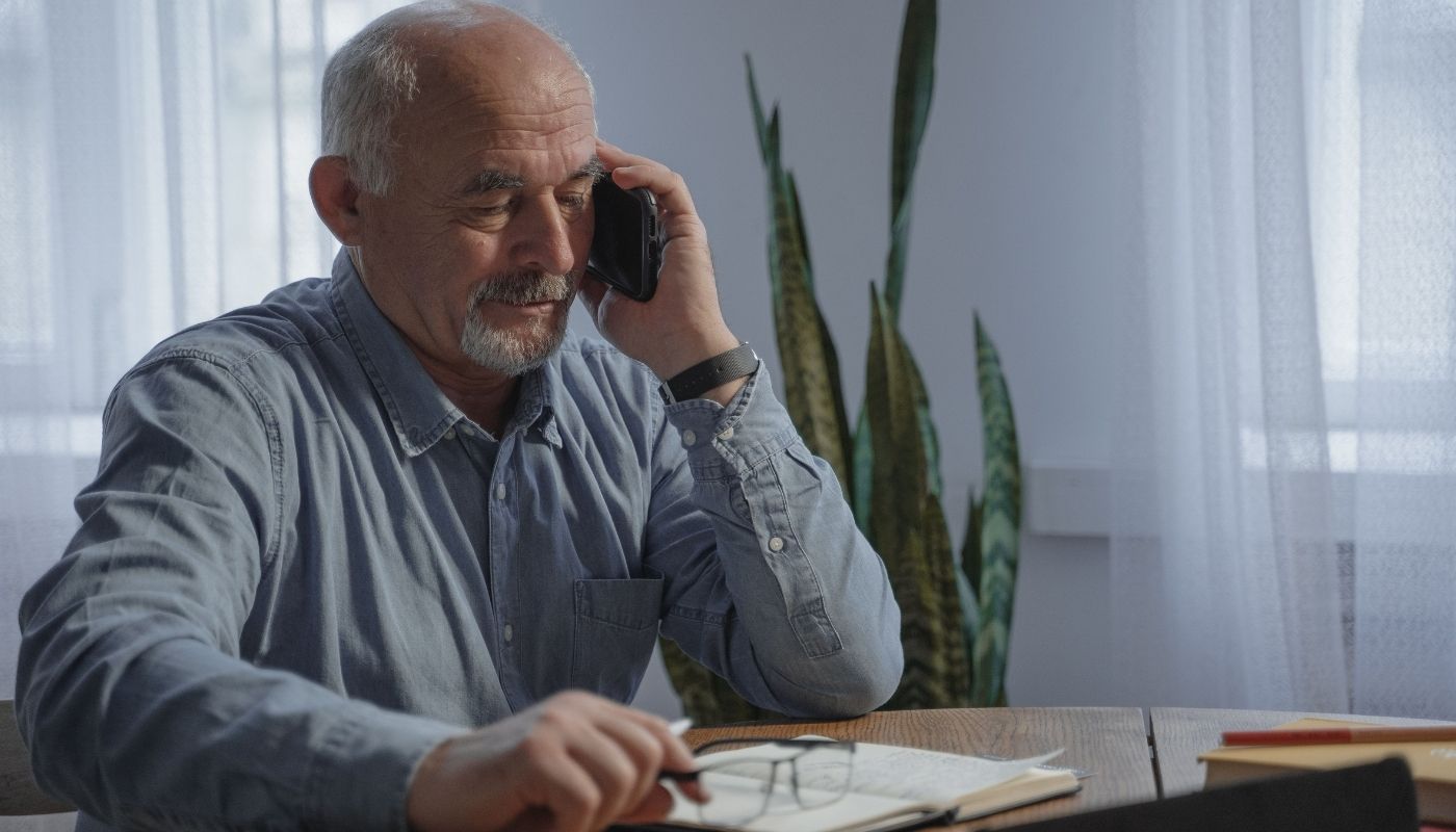 Senior male using phone to inquire about franchises for veterans