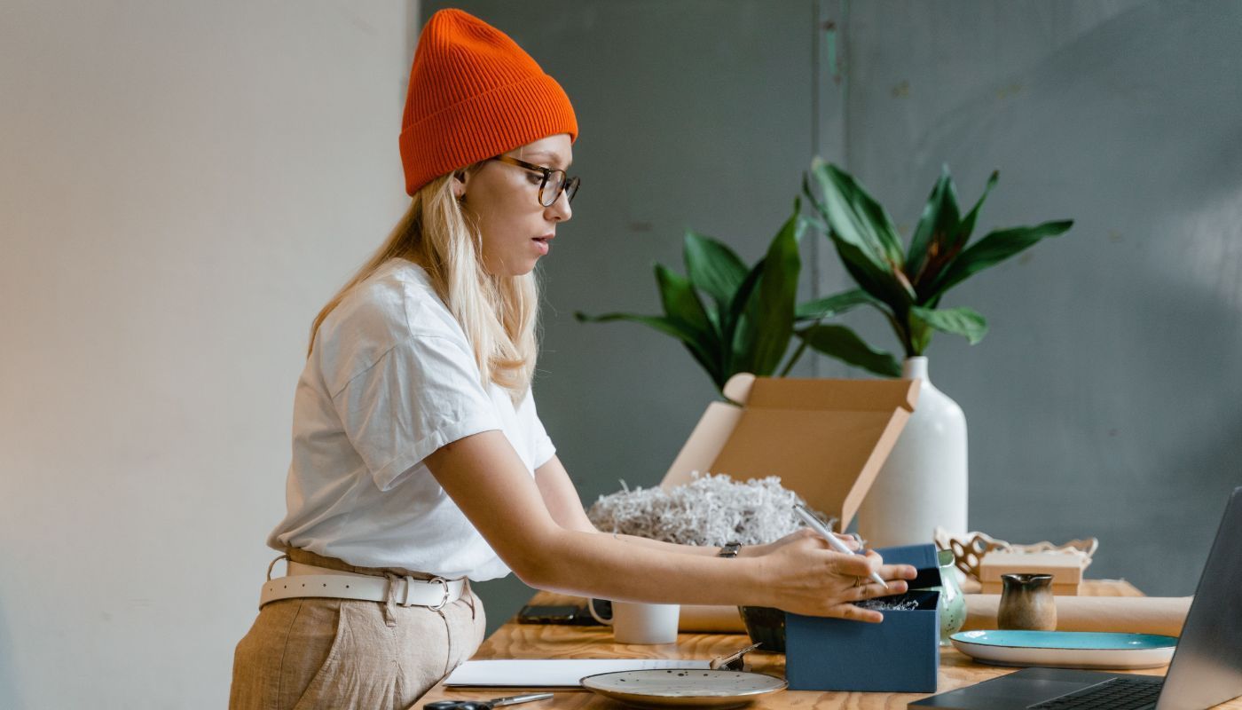 One of many Gen Z franchise owners packing customer orders at a wooden table with plants