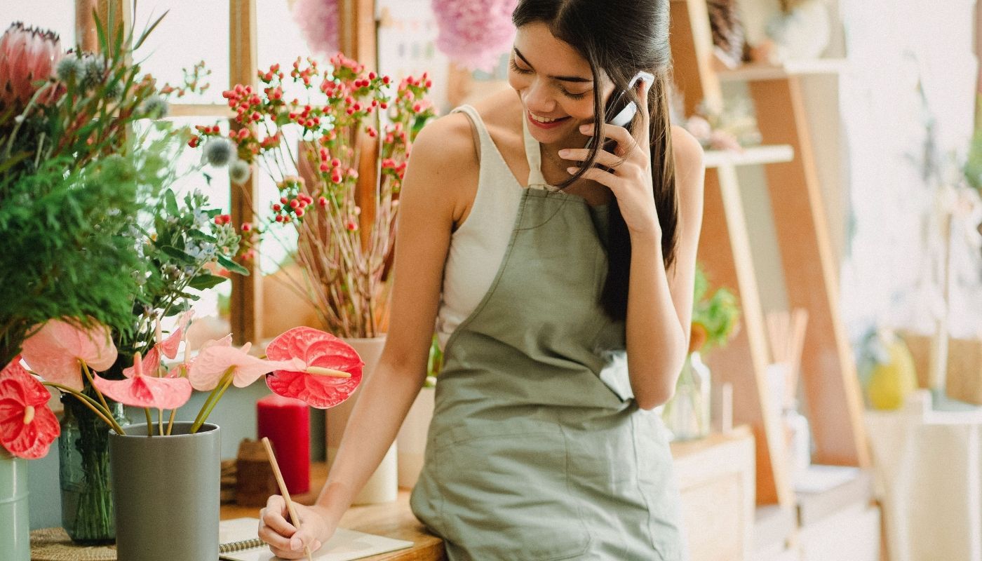 Female flower shop owner researching about how to buy a franchise