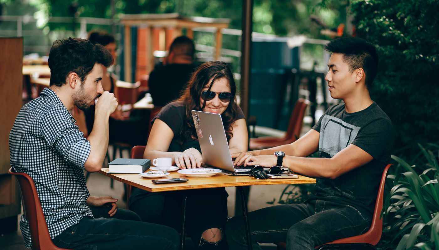 Group of millennials in franchising seated around a café table