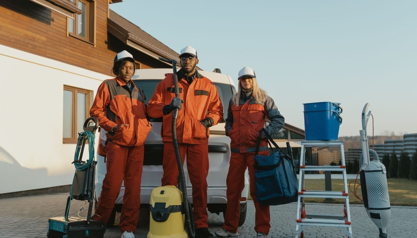 Cleaning crew standing beside their mobile unit and equipment representing successful non restaurant franchises