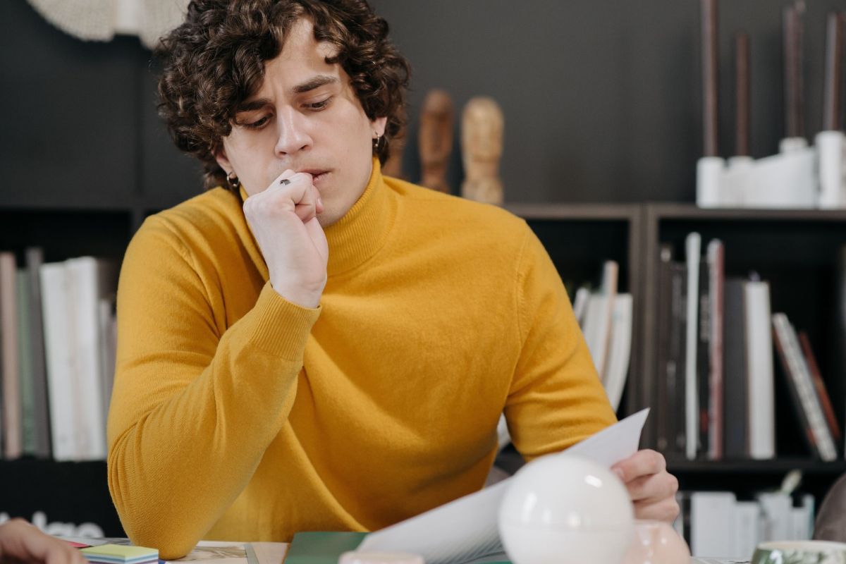 Young man in his home office desk, thinking about owning a franchise
