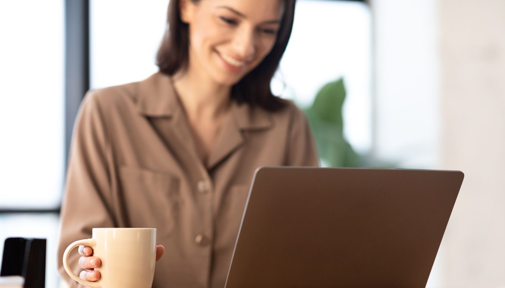 Young business owner using computer to manage the responsibilities of a franchise owner.