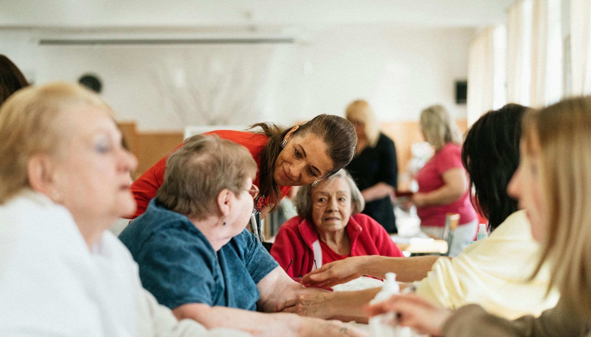 Smiling caregivers and seniors participating in activities together at a community center focused on quality senior care.