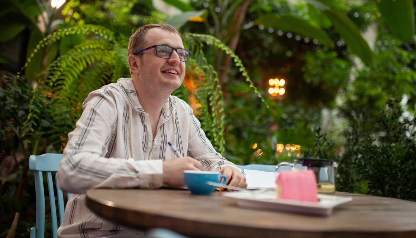 Man signing documents in a cafe, a picture of what franchise owners do