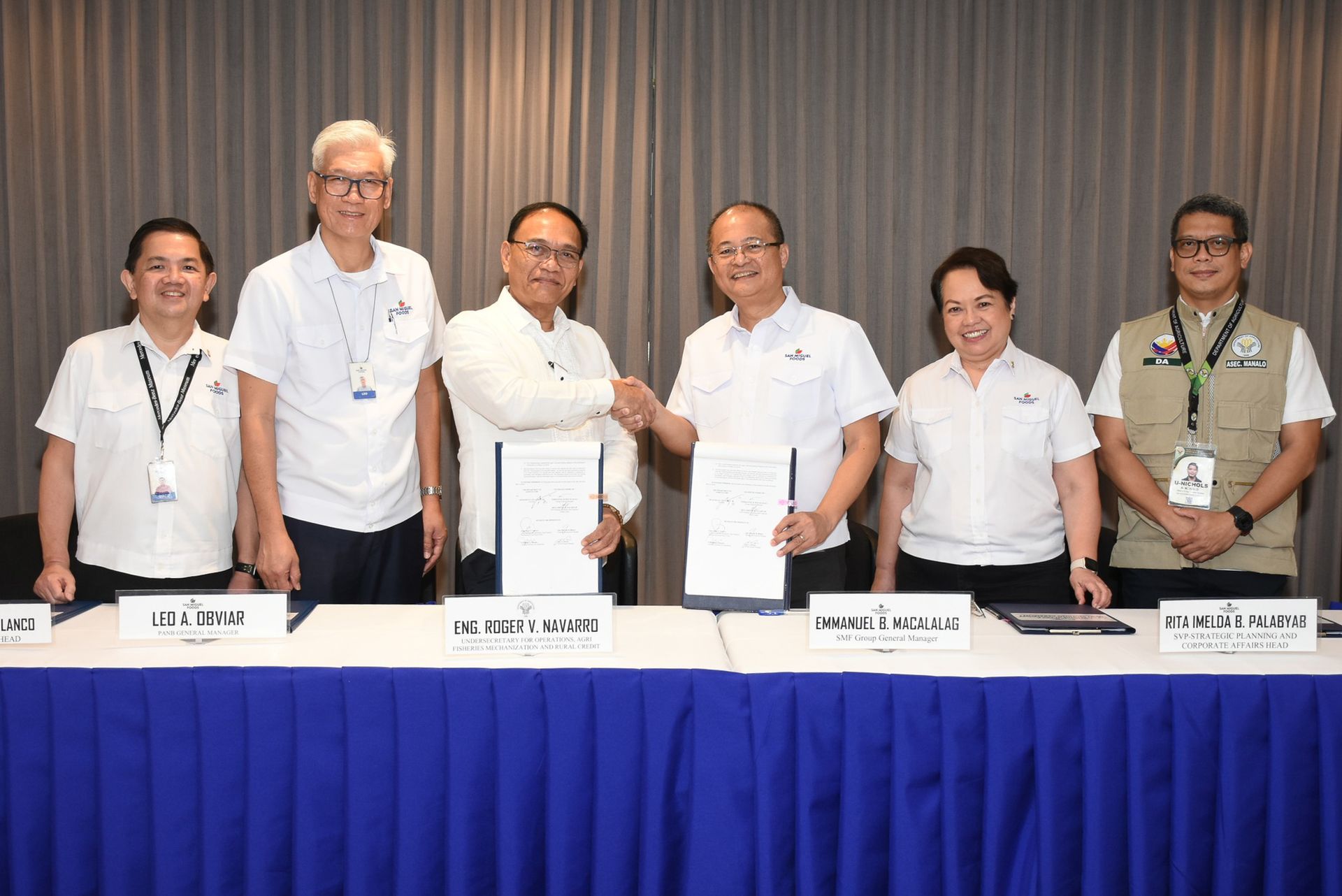 Department of Agriculture (DA) Undersecretary Roger V. Navarro (third from left) and San Miguel Foods Group General Manager Emmanuel B. Macalalag shake hands after signing their first nationwide public-private partnership (PPP) in agriculture. Others in photo are (from left) San Miguel Foods Inc. (SMFI) Protein and Animal Nutrition Business Group Head Jose Marcelo Blanco, Dr. Leo Obviar, SMFI VP and Protein and Animal Nutrition Business GM; SMFI Senior Vice President for Strategic Planning and Corporate Affairs Head Rita Imelda B. Palabyab, and DA Assistant Secretary U-Nichols A. Manalo.