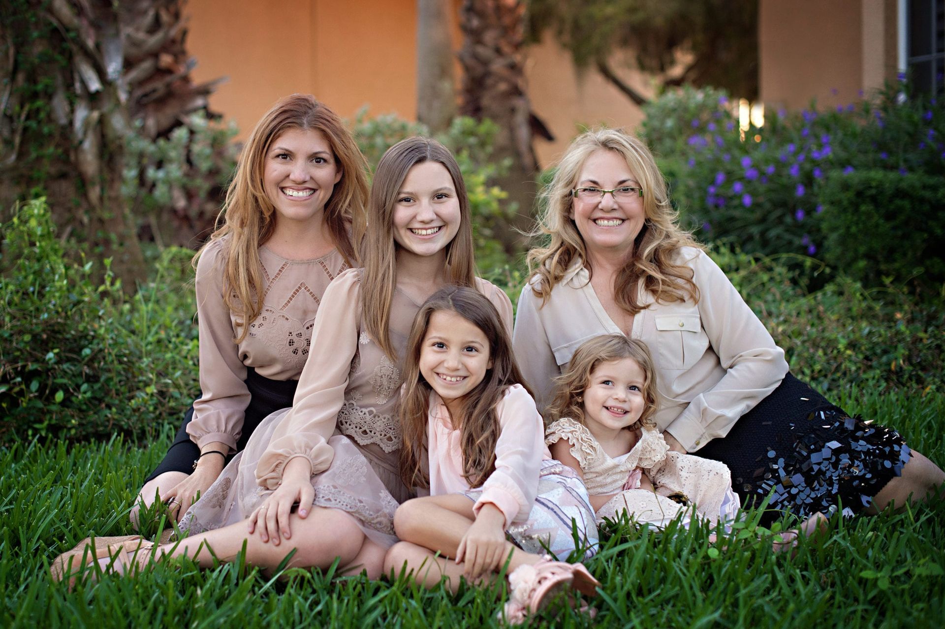 Family portrait of five women smiling on the grass.
