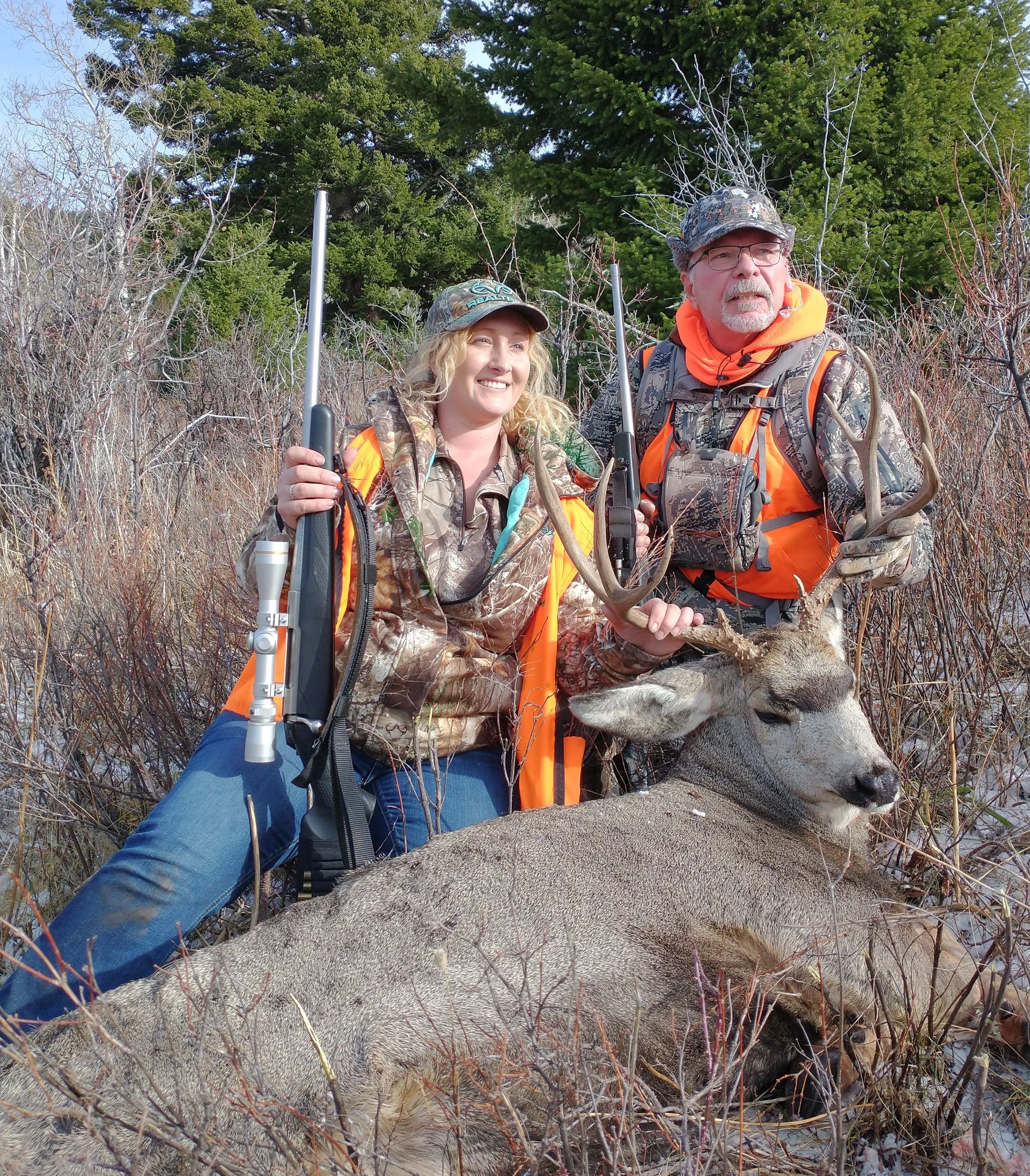A man and a woman holding a big deer.