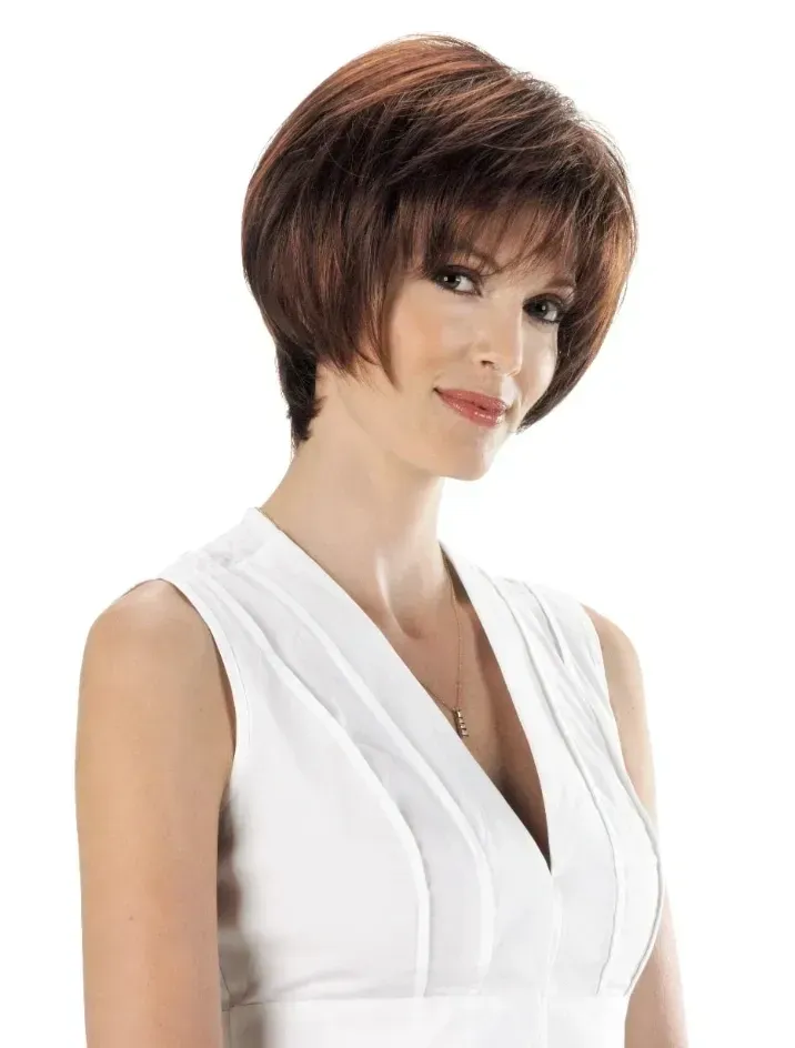 Smiling woman with short brown hair wearing a white sleeveless top against a white background
