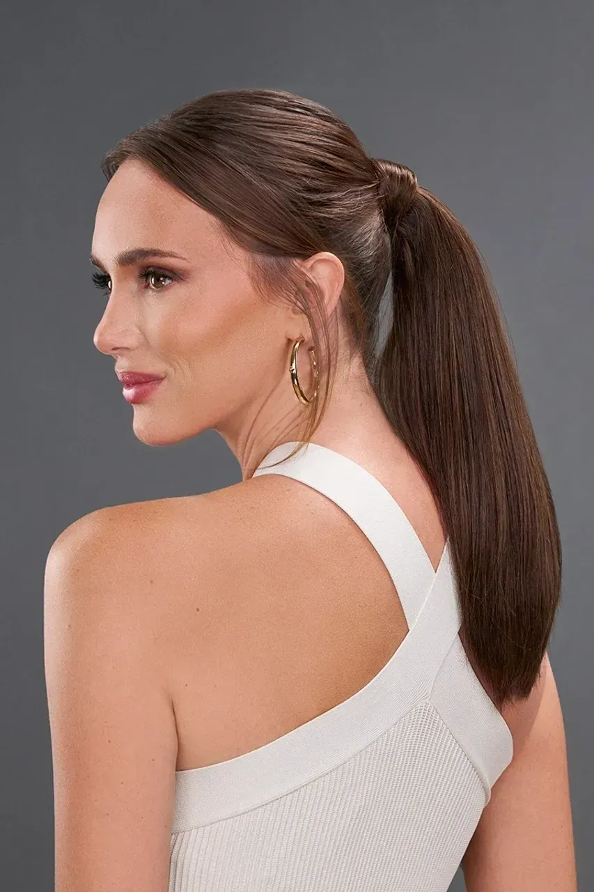 Side profile of a woman with a ponytail wearing a white sleeveless top against a gray background