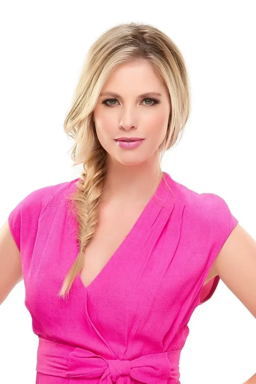 Blonde woman in a bright pink dress posing against a white background