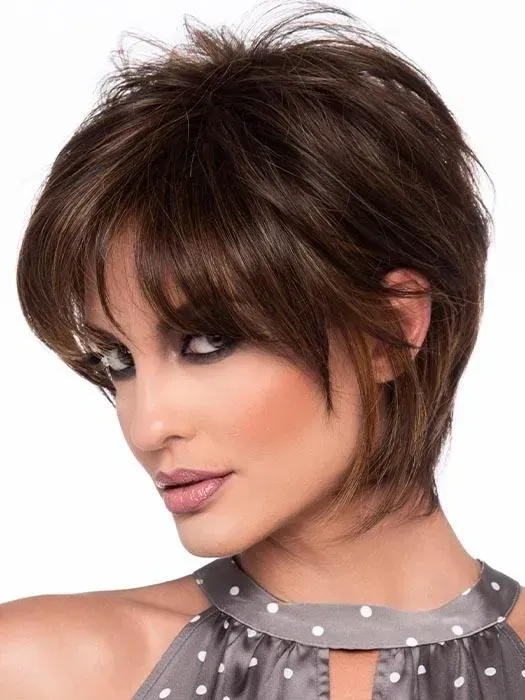 Portrait of a woman with short layered brown hair and smoky eye makeup, wearing a gray polka-dot halter top.