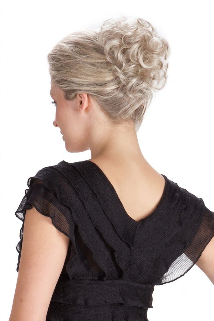 Portrait of a person with short blonde hair in a black halter top against a white background