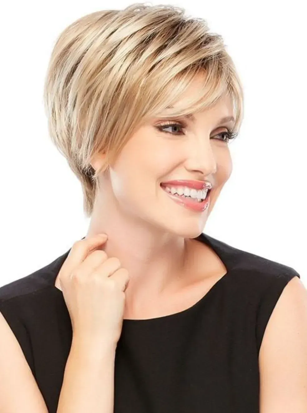 Smiling person with short blonde hair in a black top against a white background