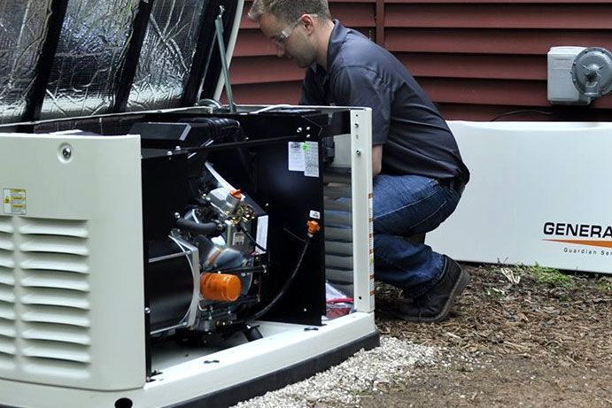  Integrity Energy Systems A man is working on a generator with the lid open