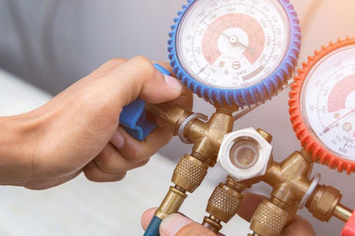 Integrity Energy Systems A person is holding a couple of gauges in their hands.
