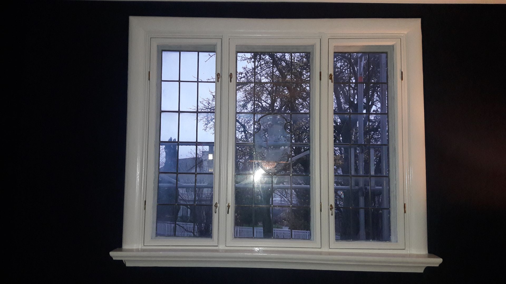 A window with a reflection of trees in it