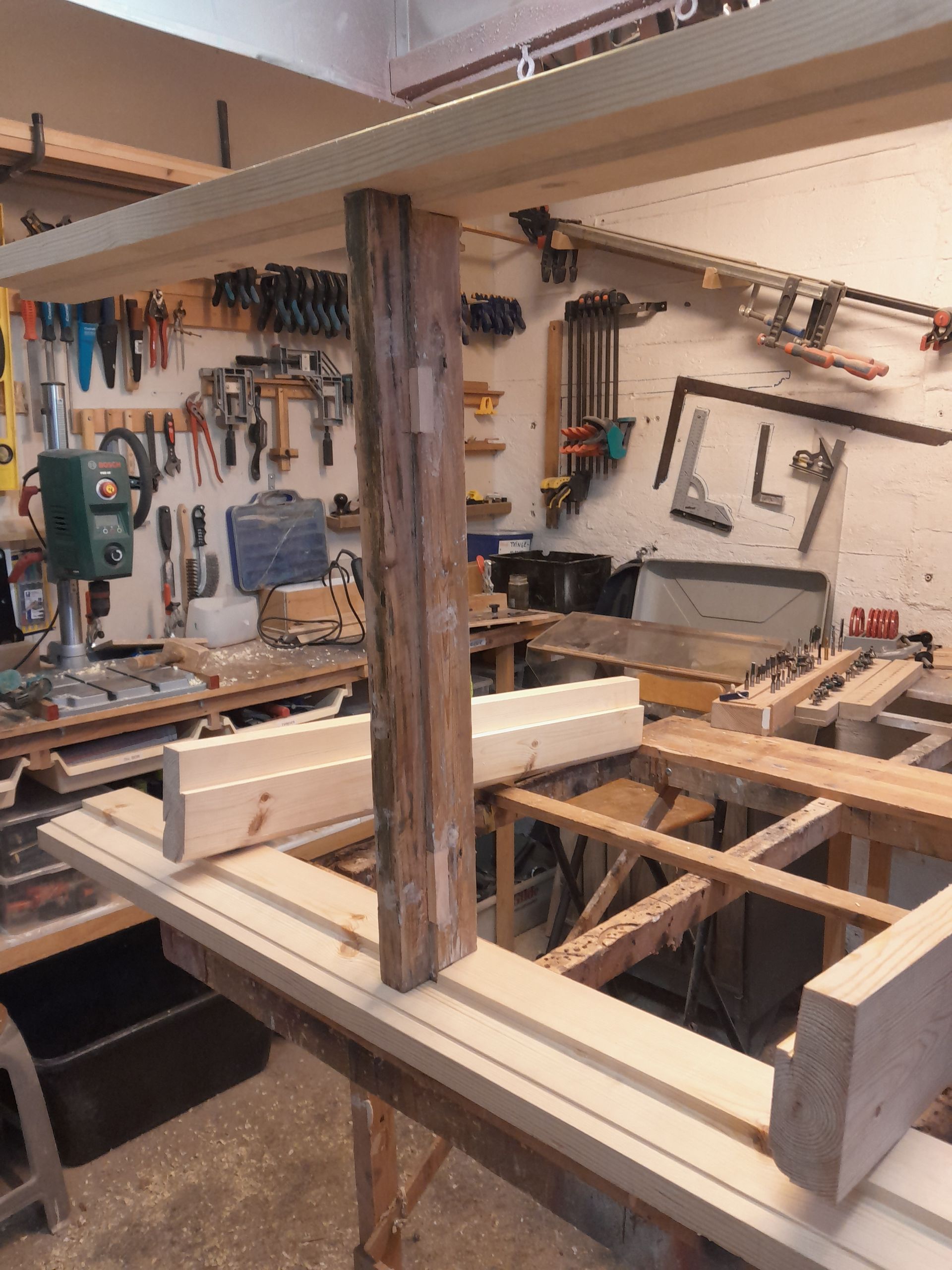 A woodworking shop with a lot of wood and tools
