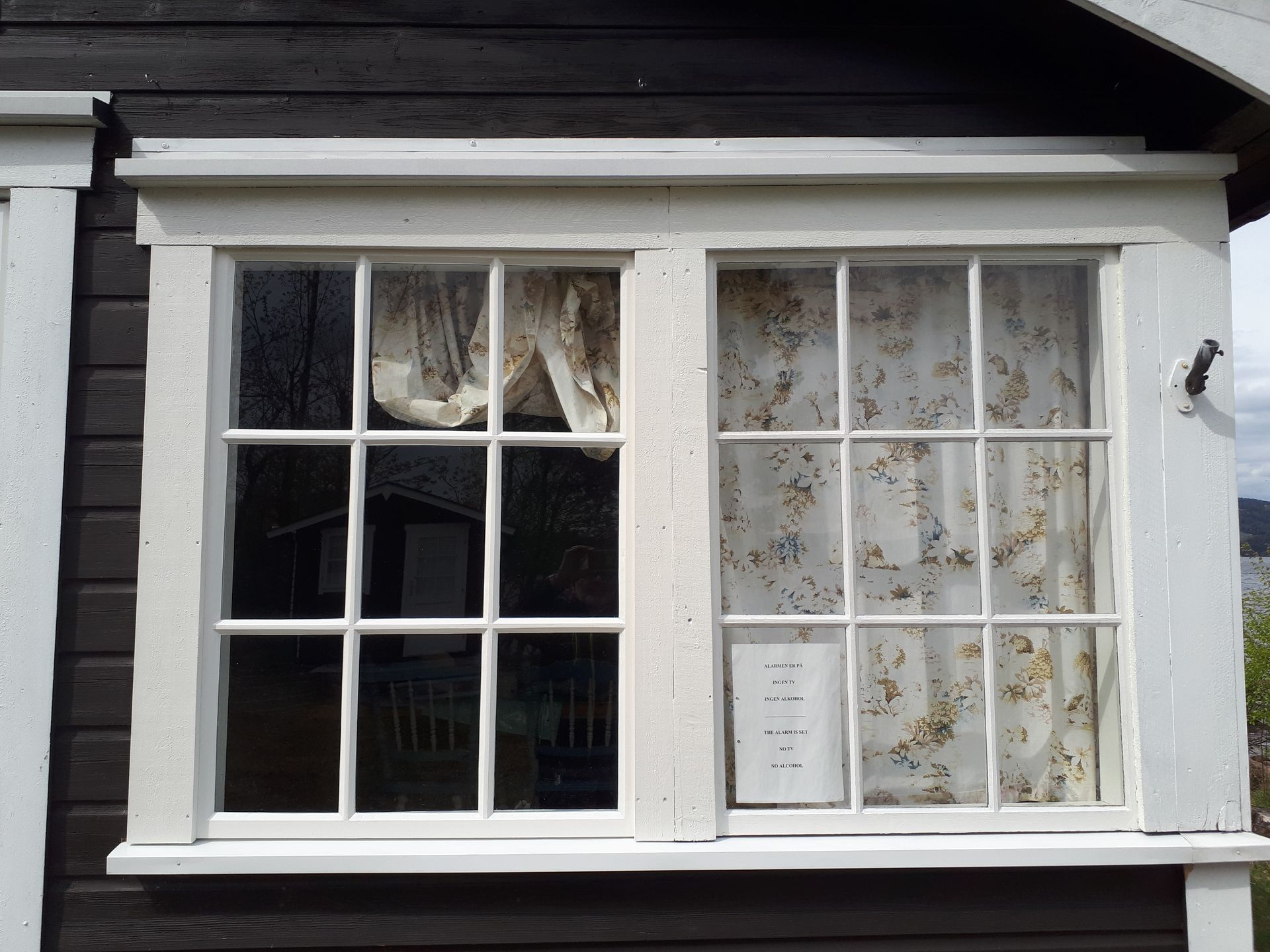 A white window with a floral curtain on it