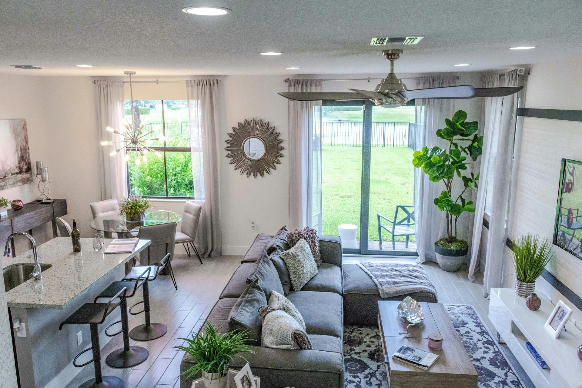 Modern living room with sectional sofa, dining table, and sliding glass door to backyard.