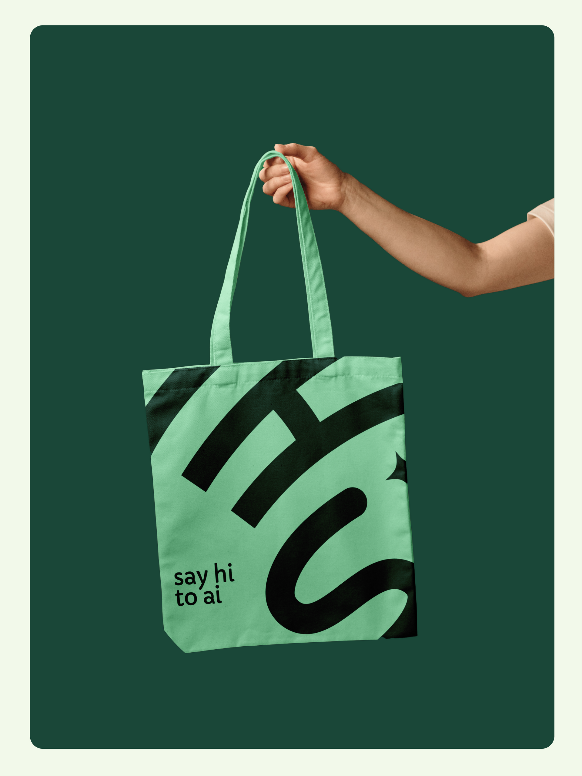 A hand holds a light green tote bag with black text: