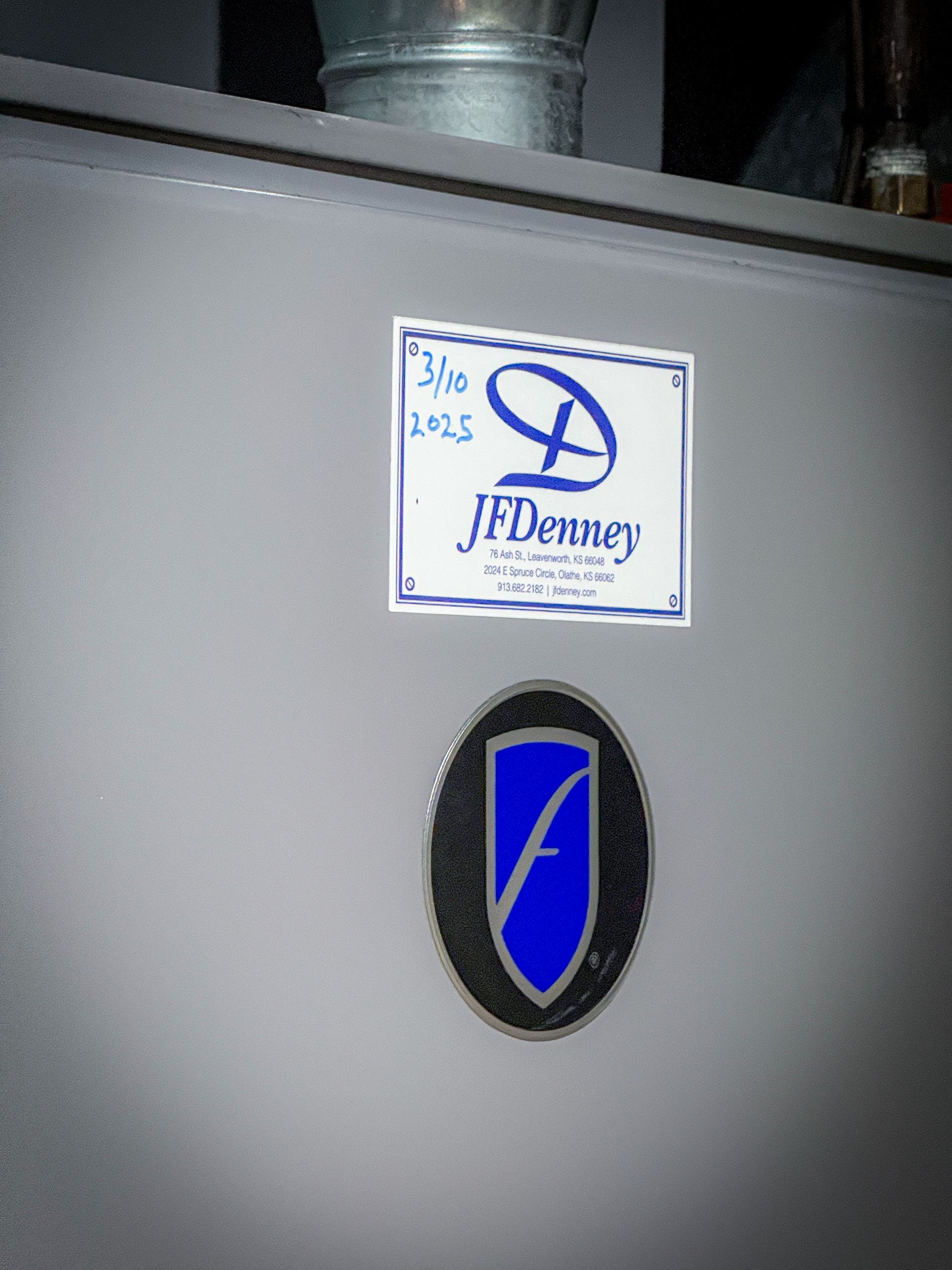 Furnace cabinet with a J F Denney service sticker.