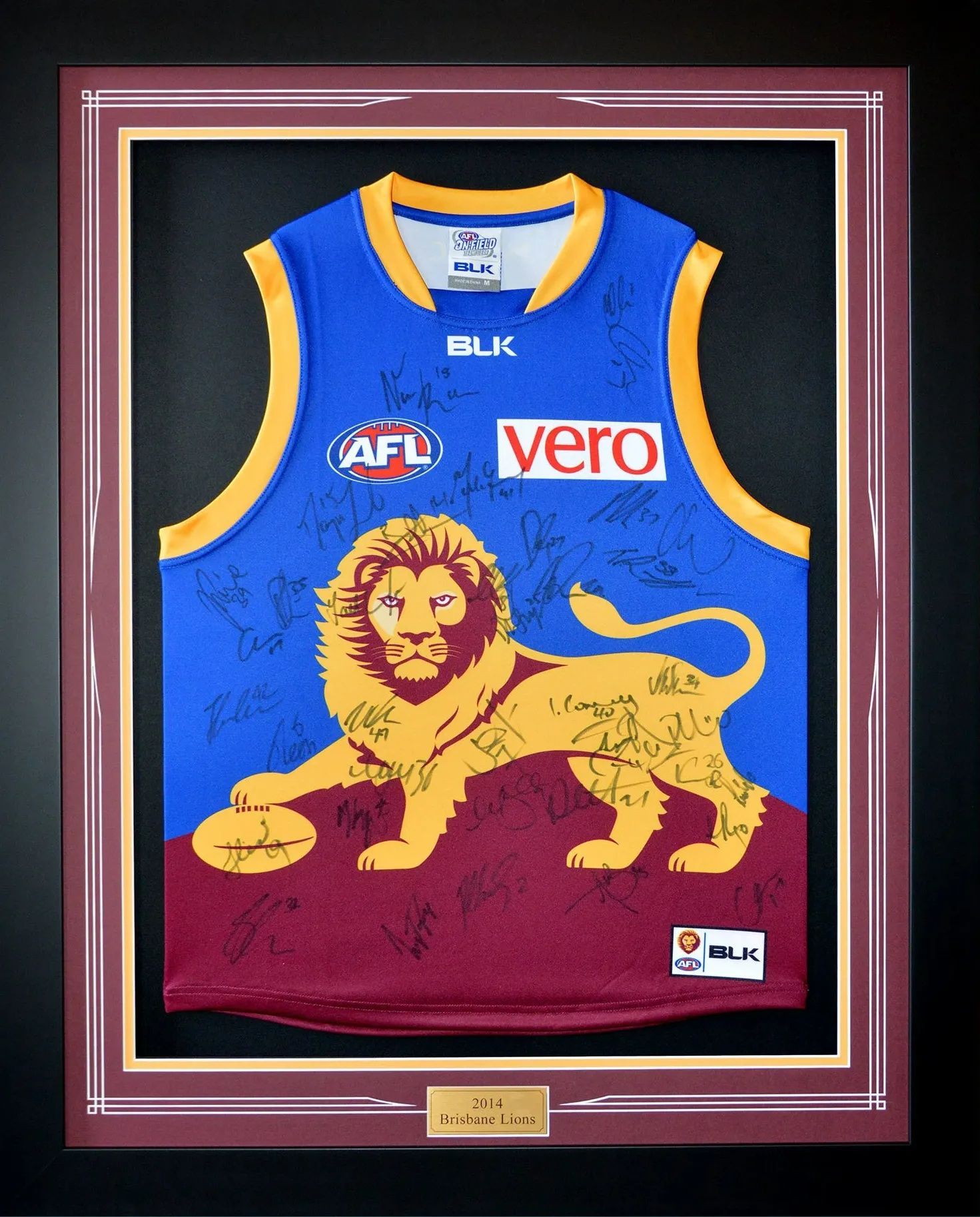 Framed blue and gold AFL jersey with lion graphic, BLK and Vero logos, on display in a maroon case