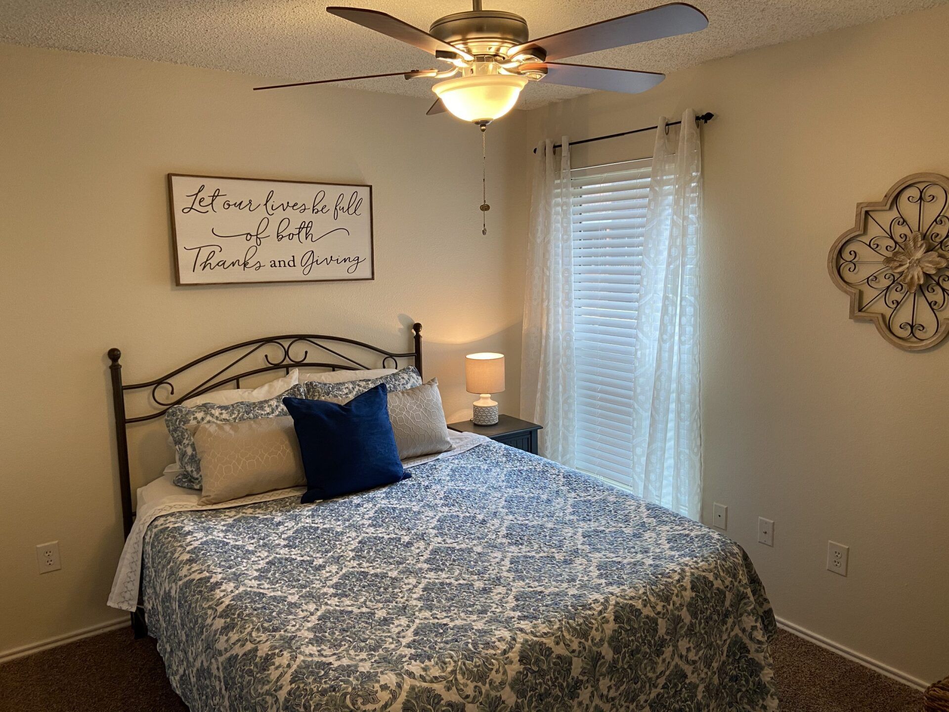 Interior of bedroom with large fan overhead and window