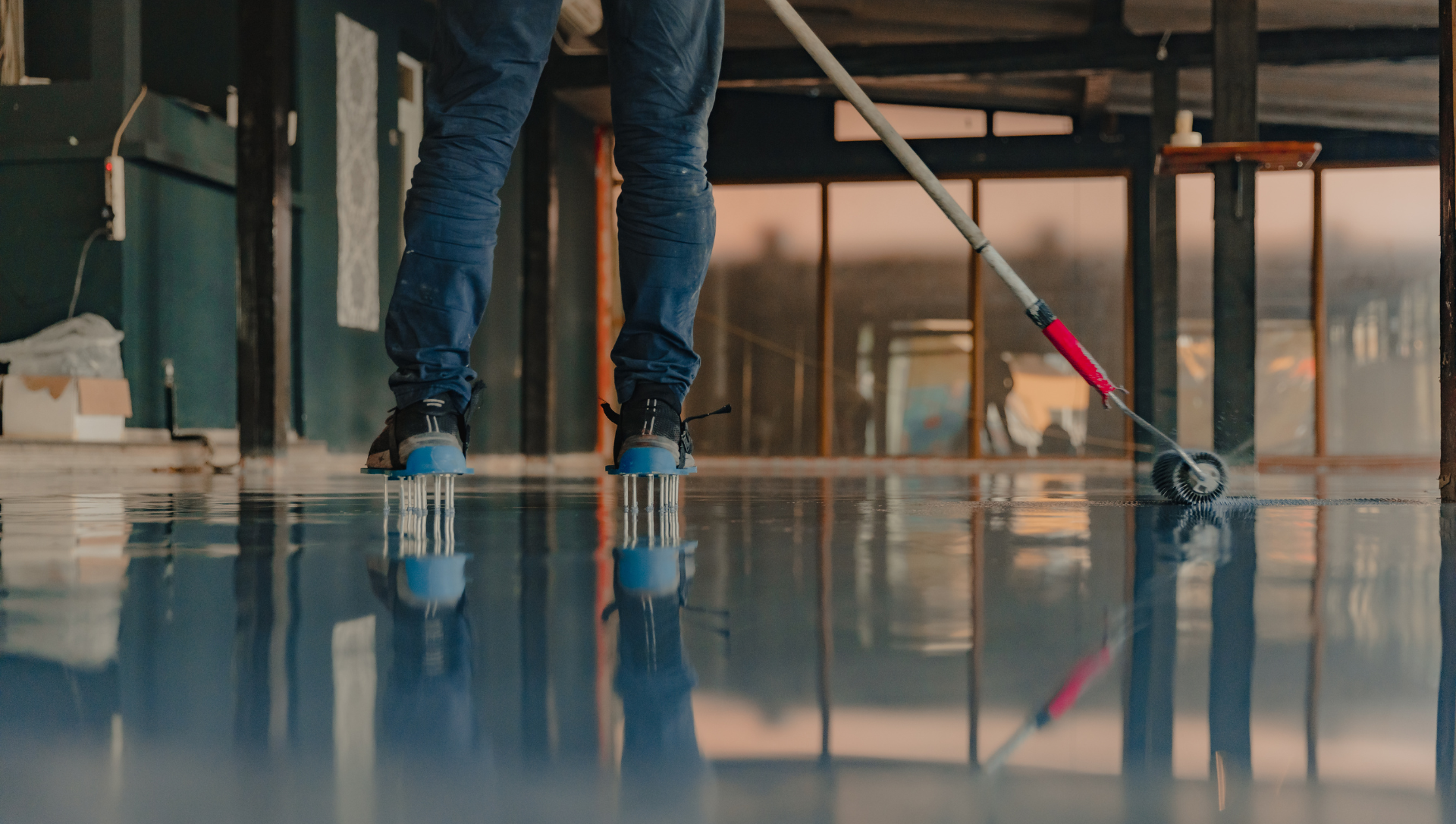 Crew member rolling epoxy on warehouse floor
