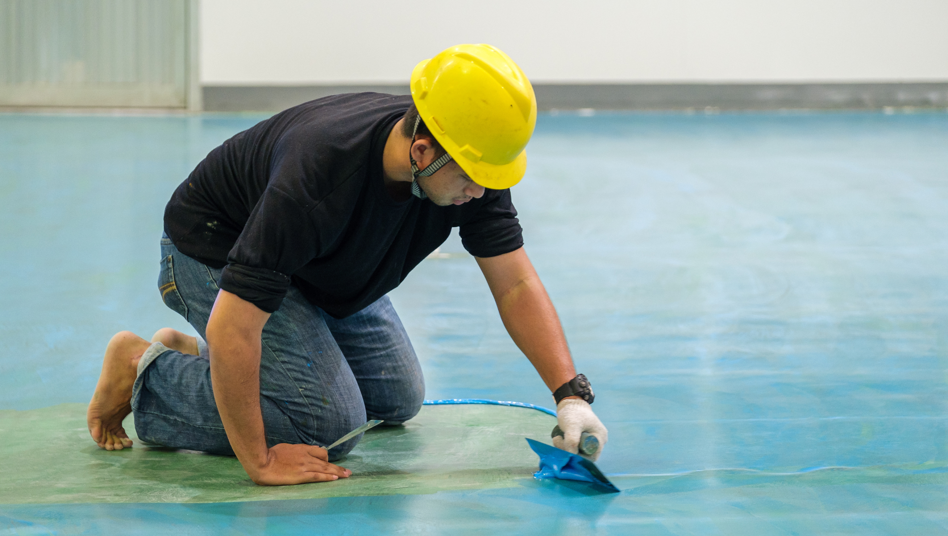 Epoxy expert spreading epoxy on commercial building