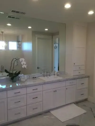 A bathroom with two sinks and a large mirror.