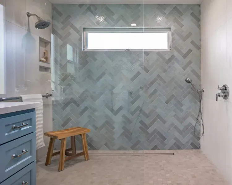 A bathroom with a walk in shower and a window.
