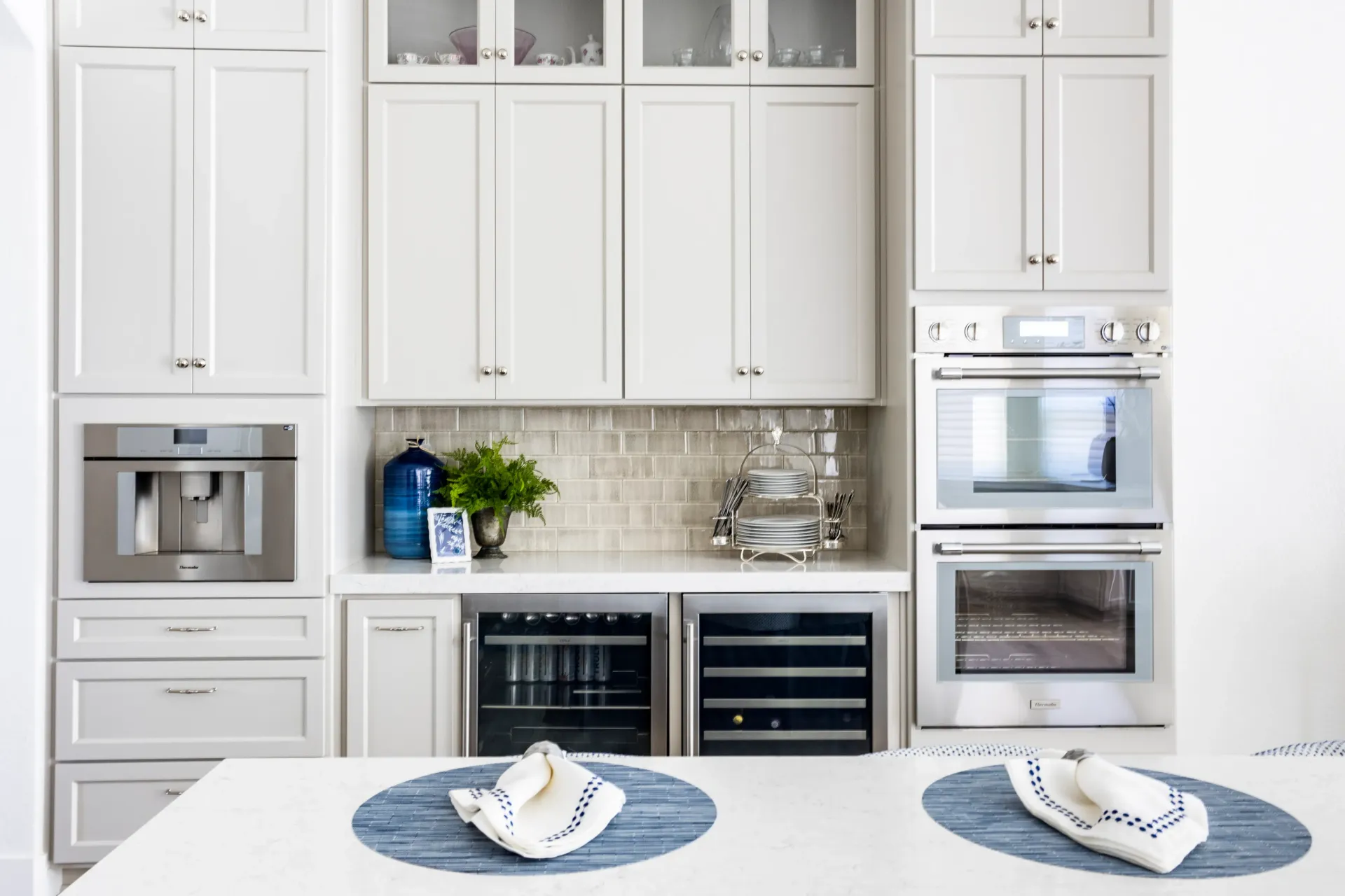 A kitchen with white cabinets and stainless steel appliances.