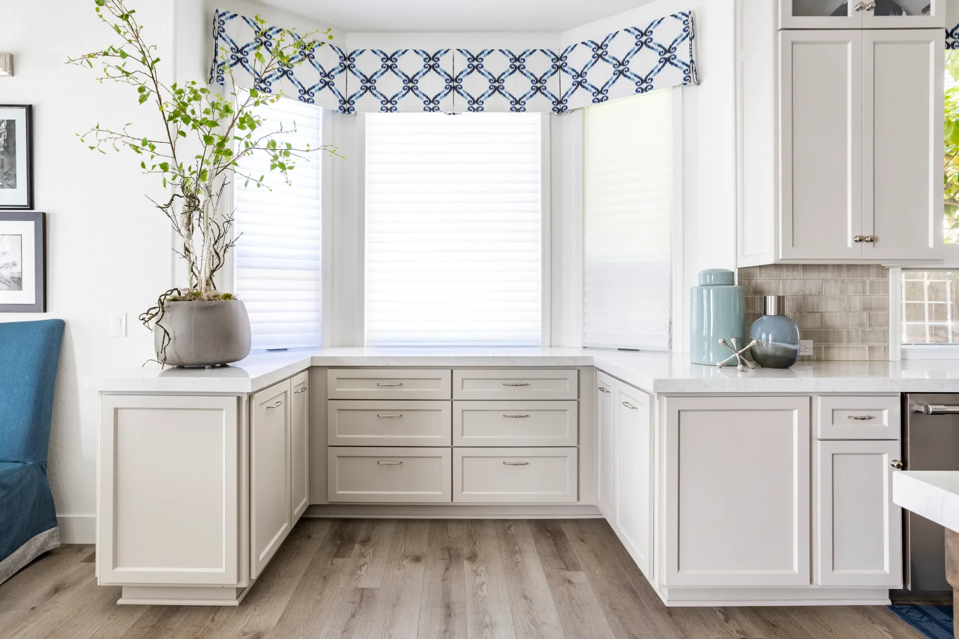 A kitchen with white cabinets , a window , a sink , and a dishwasher.