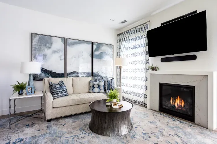 A living room with a couch , fireplace , television and coffee table.
