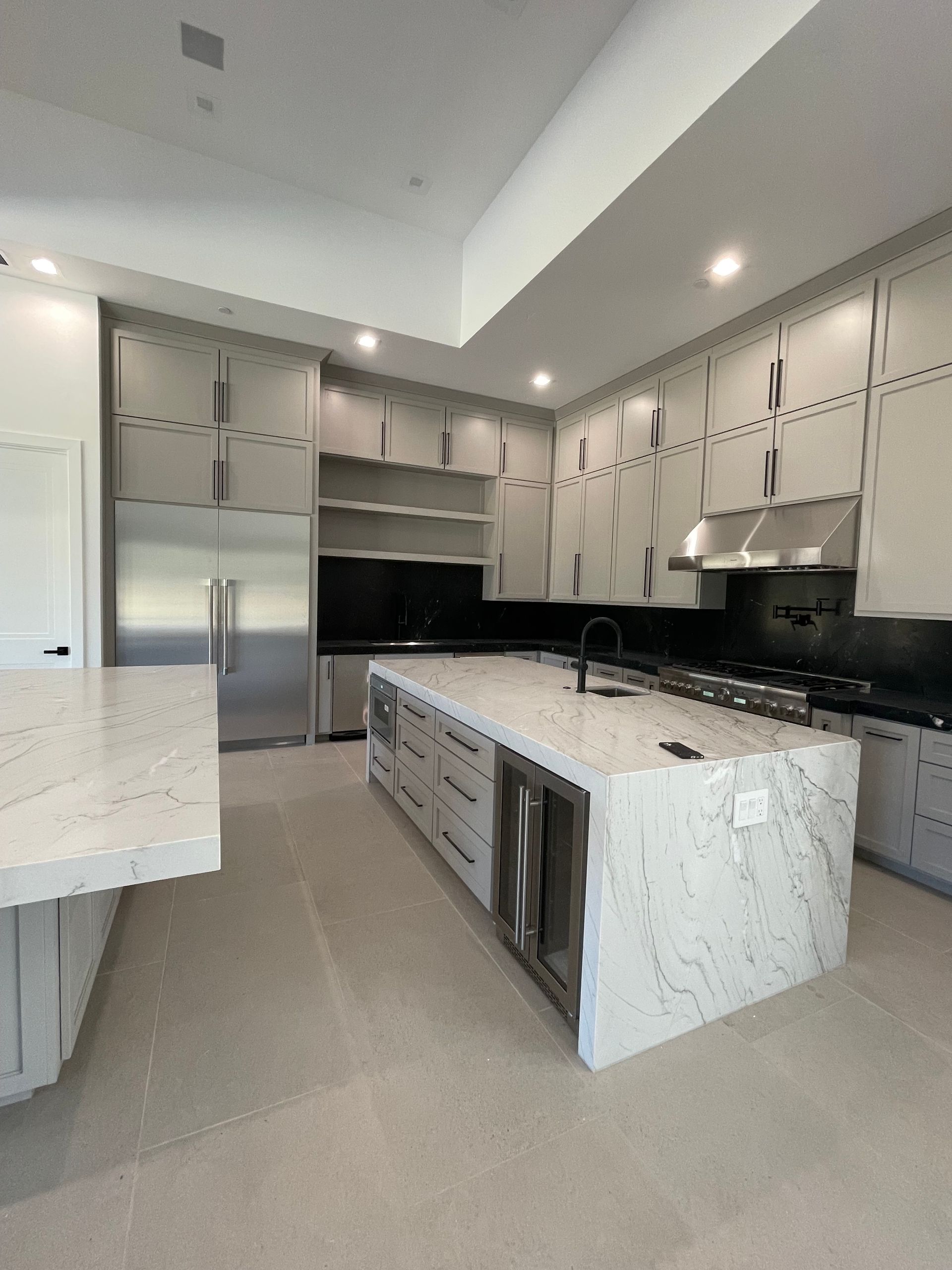 A kitchen with a large island and stainless steel appliances