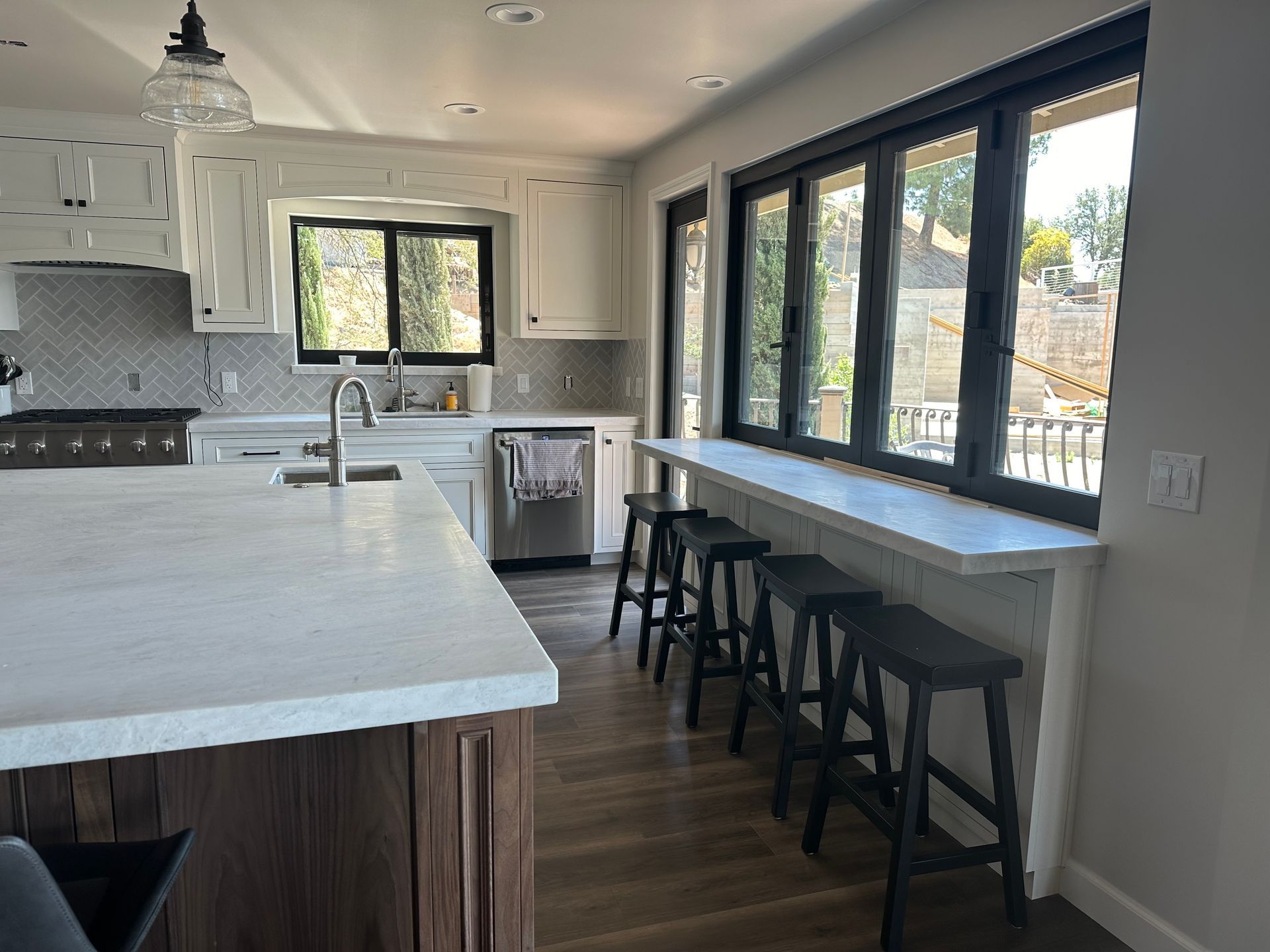 A kitchen with a lot of windows and stools