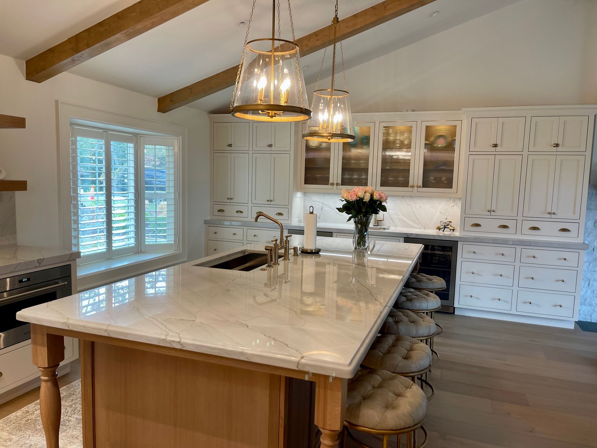 A kitchen with white cabinets and a large island in the middle.