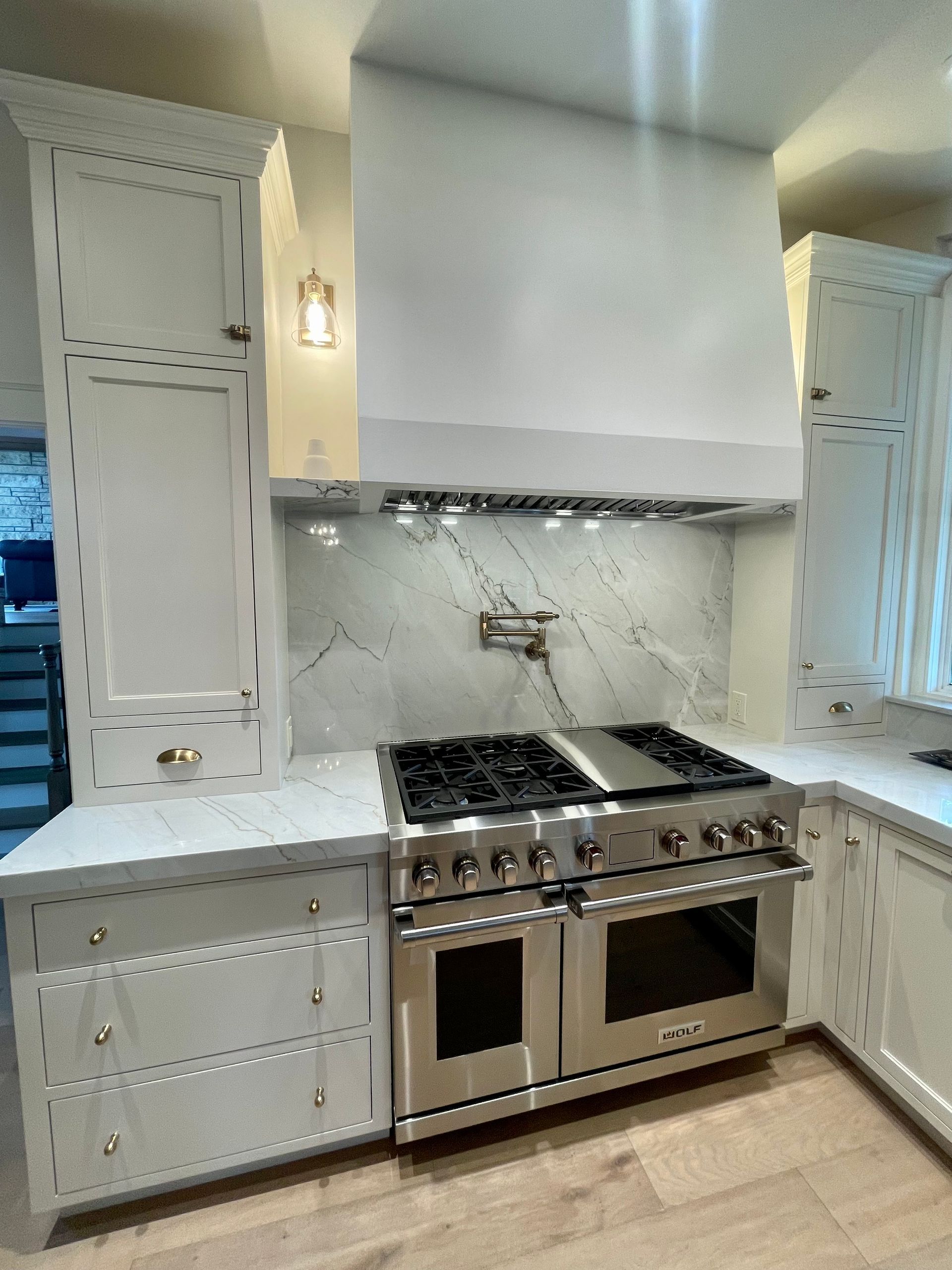 A kitchen with stainless steel appliances and white cabinets.