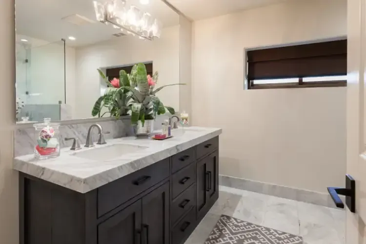 A bathroom with two sinks and a large mirror.