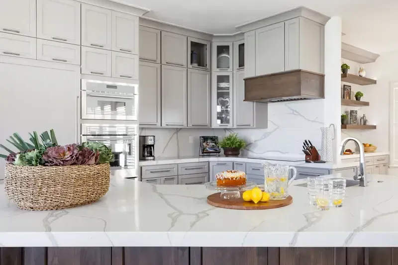 A kitchen with white cabinets and a white counter top.